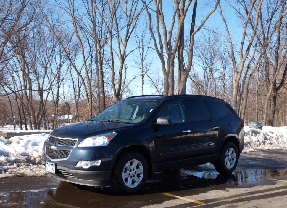 Front side view of a black mid-size SUV parked in a snowy outdoor setting