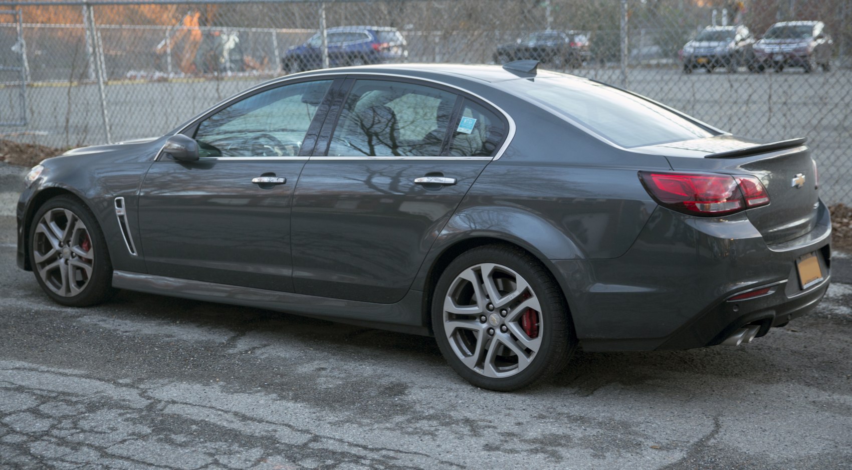 Side and rear view of a sedan with alloy wheels and rear spoiler