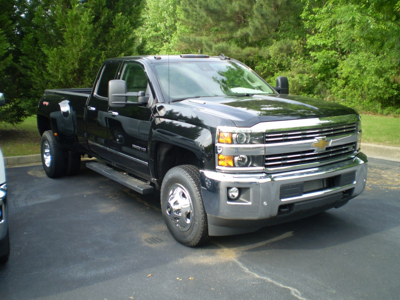 Heavy duty pickup with double cab, long cargo box, and dual rear wheels.