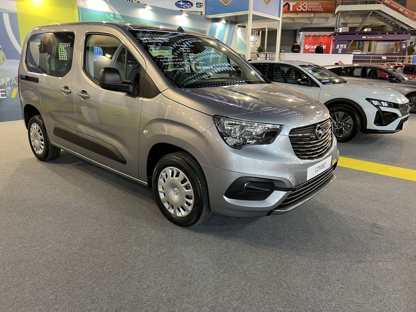 Silver compact van with large windows and prominent front grille