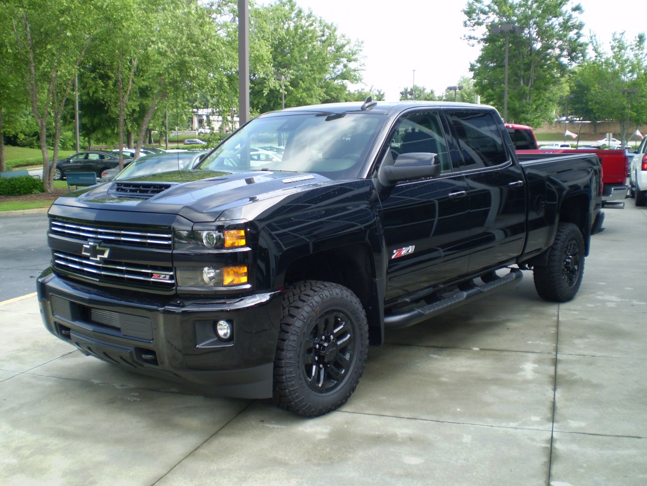 Black heavy duty crew cab pickup with aggressive front and off-road wheels