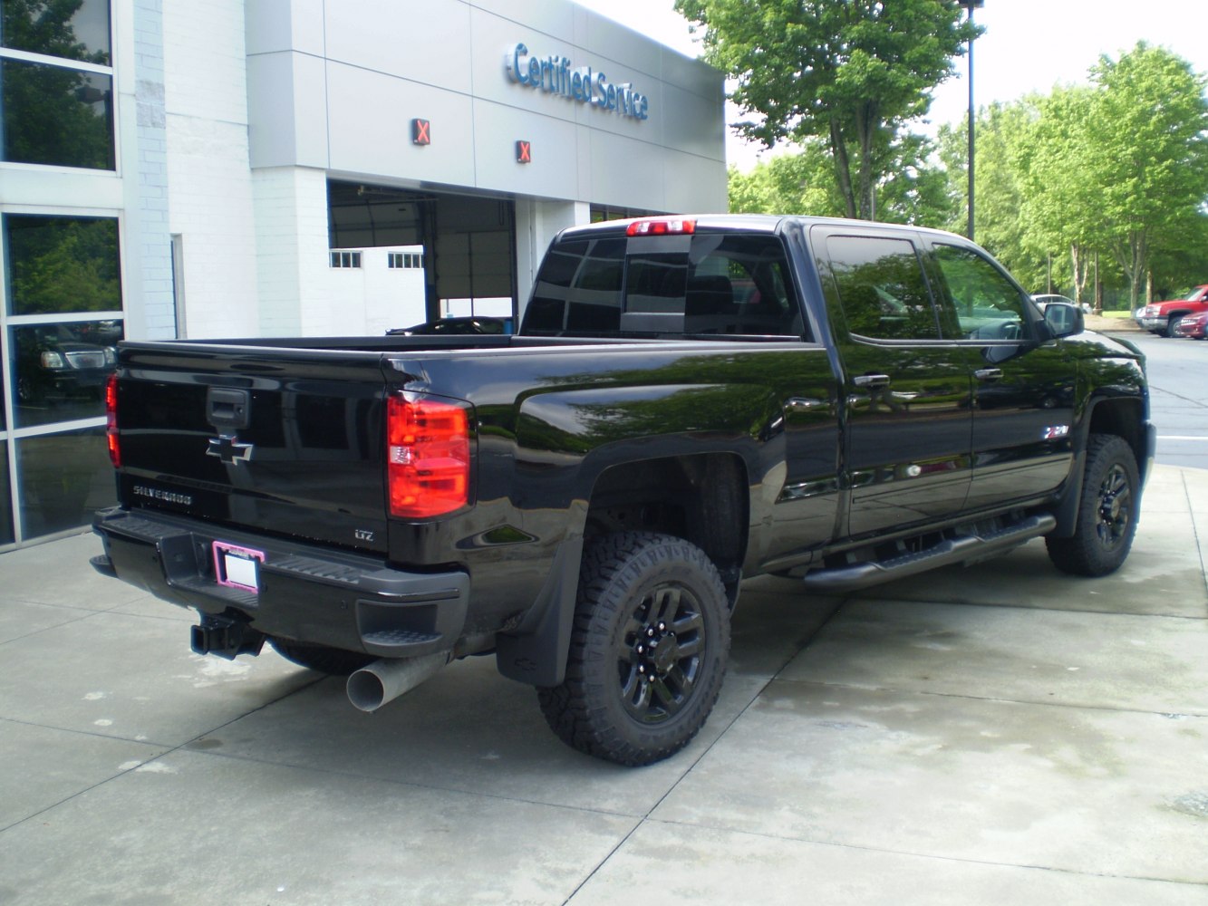 Rear and side view of a black crew cab pickup with off-road tires