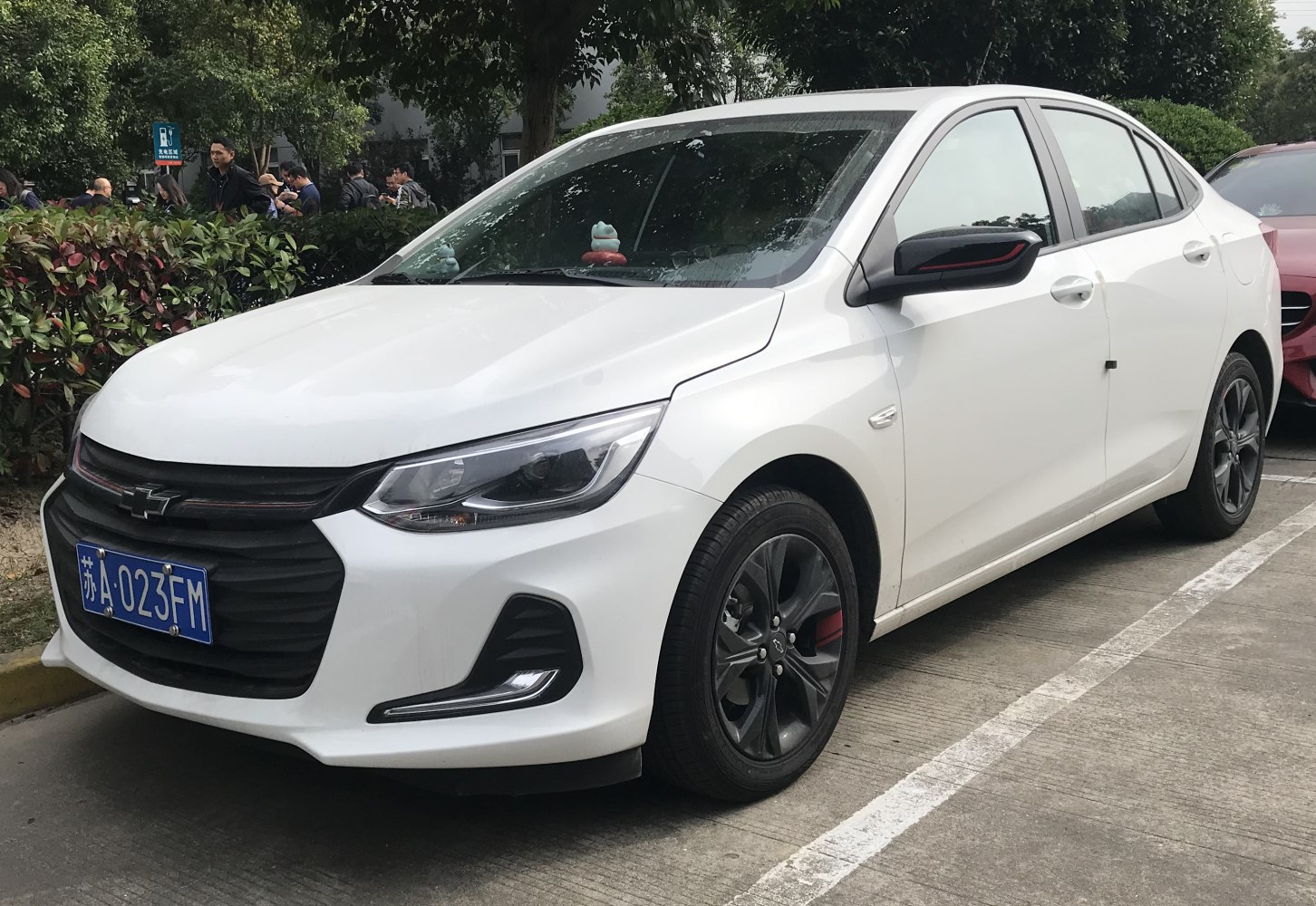Front and side view of white sedan with black grille and alloy wheels