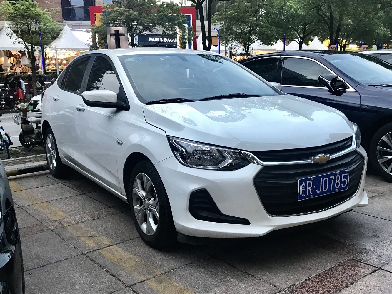 Front section with headlights, grille, and wheels of a white sedan