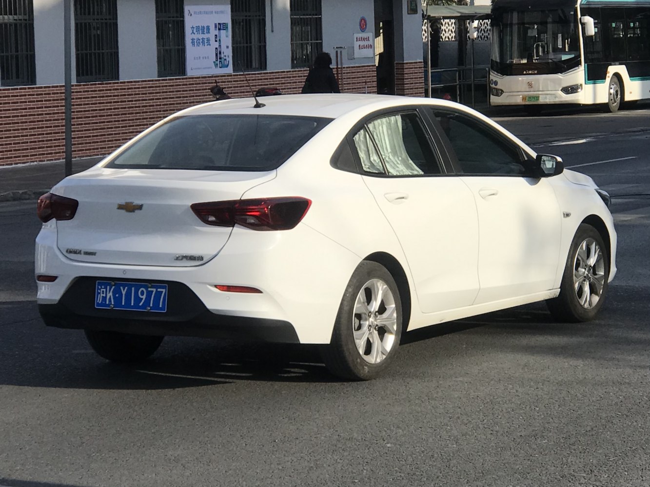 White sedan rear side view with sleek taillights and alloy wheels
