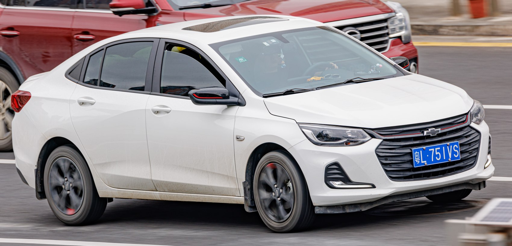 White mid-size sedan with black alloy wheels and tinted windows