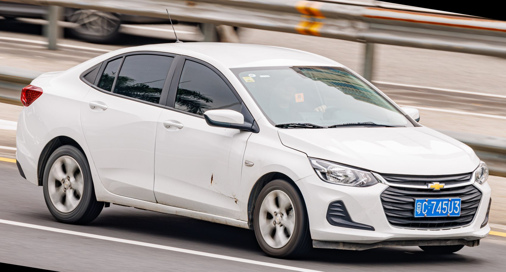 White sedan with prominent front grille and alloy wheels