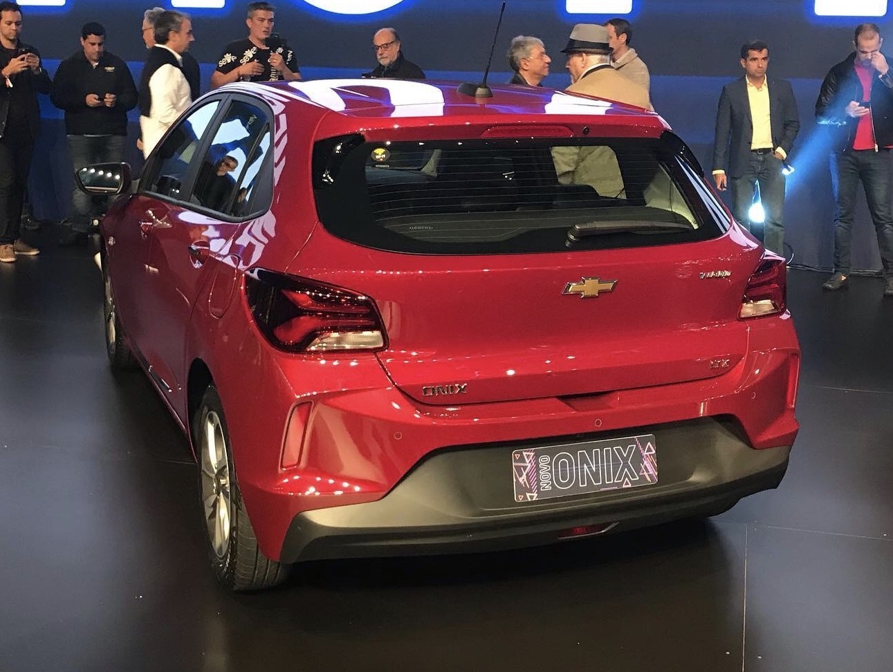 Rear view of a red hatchback with modern taillights and hatch design.
