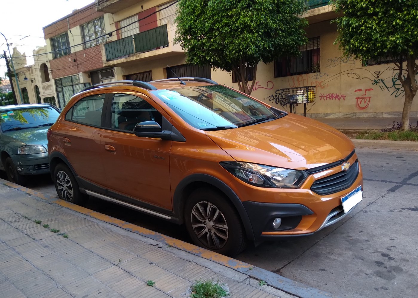 Orange urban crossover with roof rails and sleek front headlights
