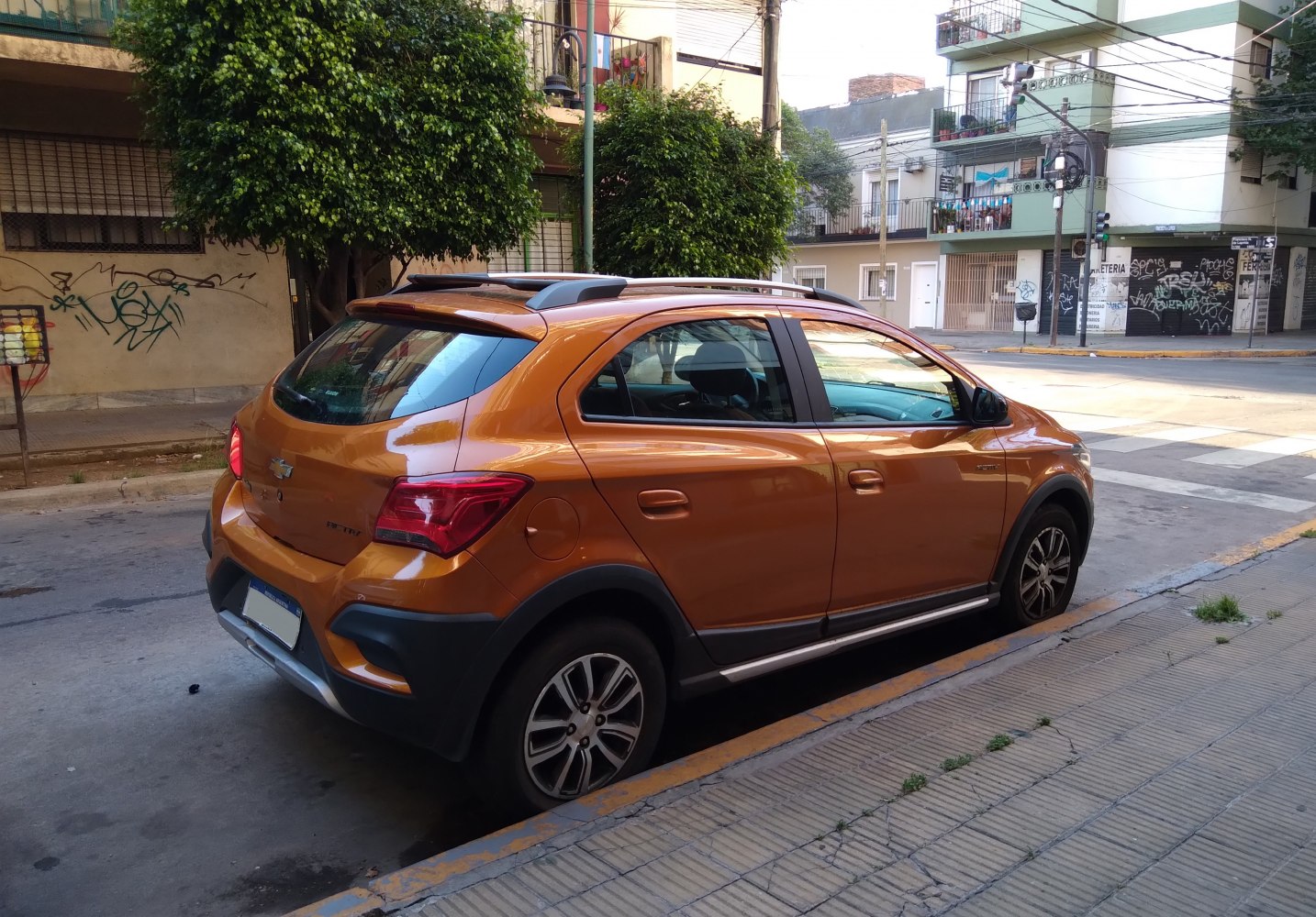 Orange compact hatchback with roof rails and alloy wheels