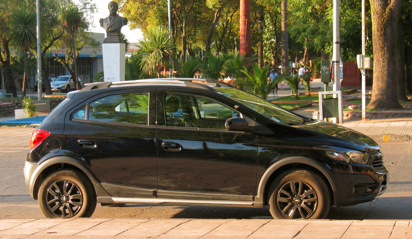 Side profile of a compact hatchback with alloy wheels and roof rails