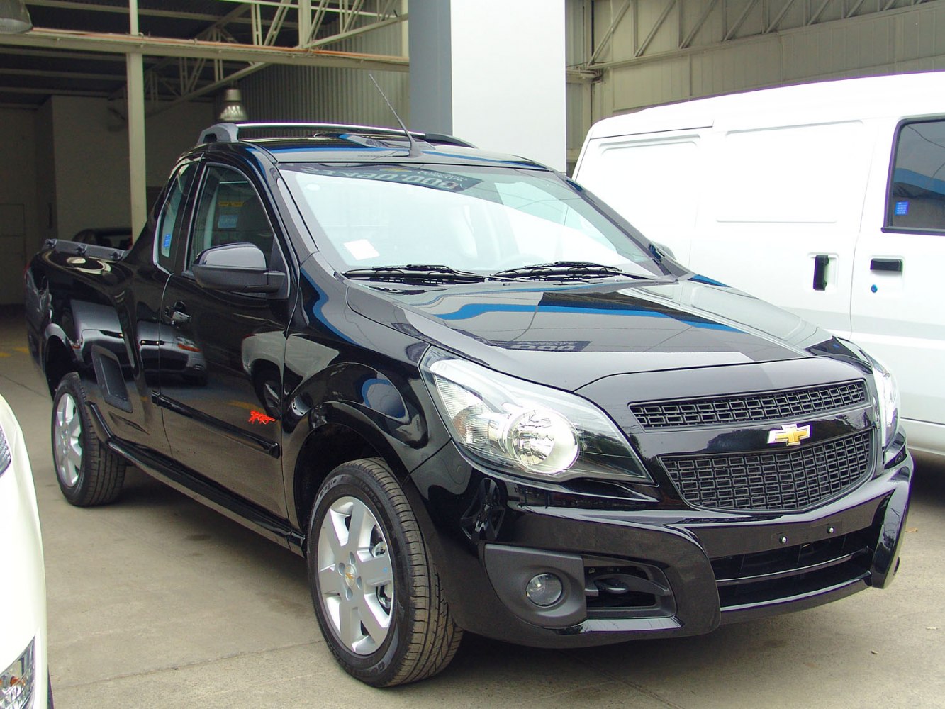 Black compact pickup truck with distinctive grille and headlights
