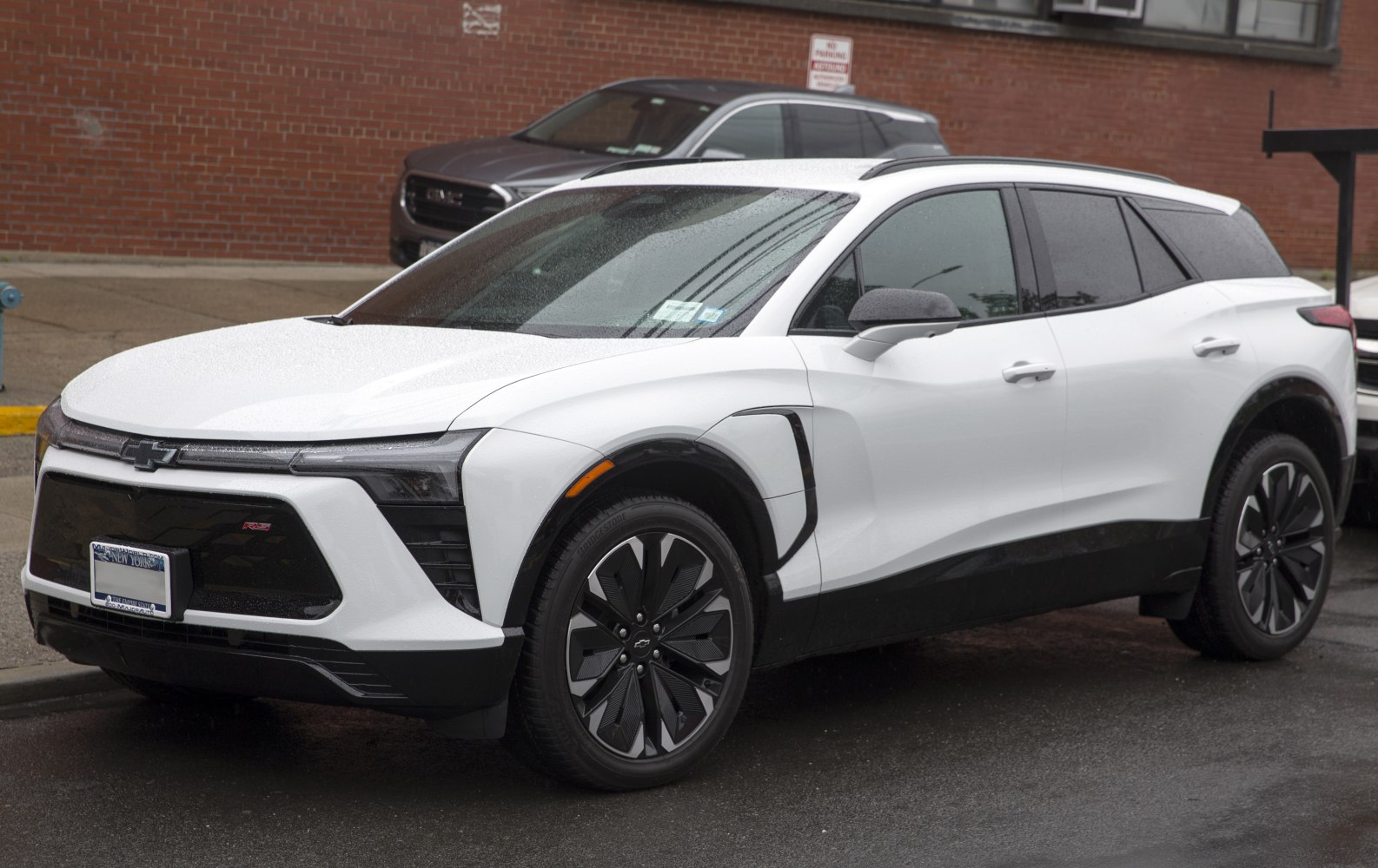 White electric SUV with RS badge, aerodynamic front, black trim, and distinctive alloy wheels