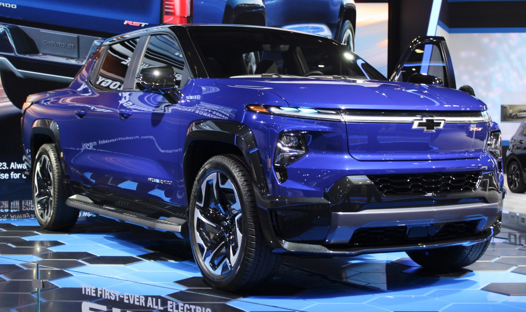 Electric pickup with LED headlights, bold grille, and alloy wheels.