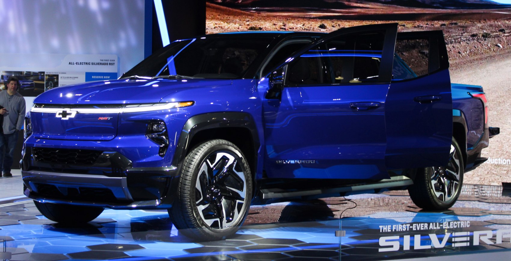 Sleek LED headlights and distinctive alloy wheels on a blue electric crew cab truck