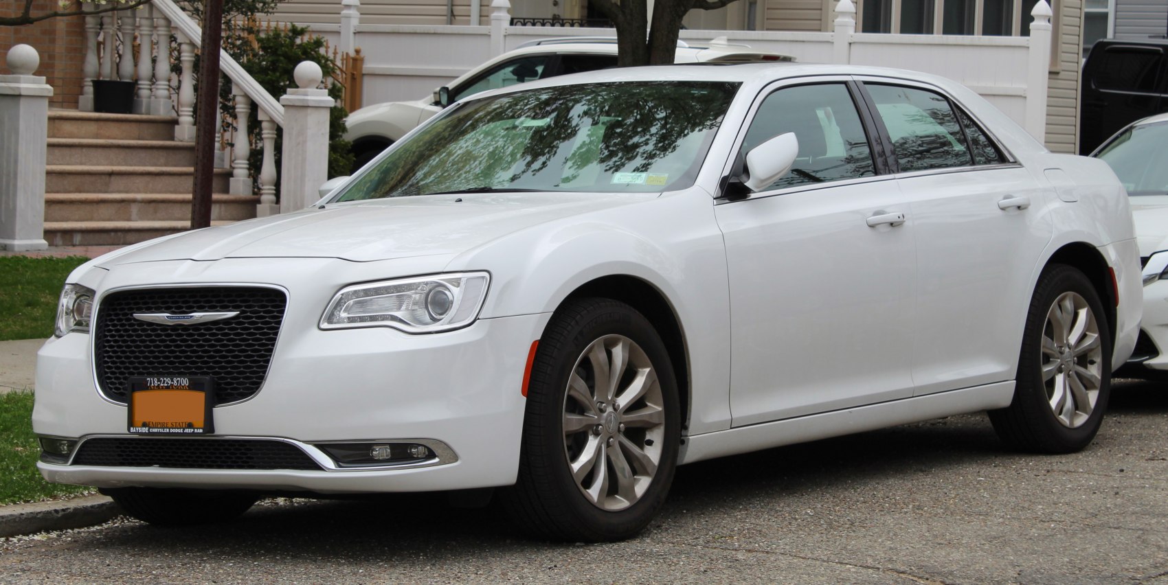 Front-left side view of white sedan with prominent grille and alloy wheels
