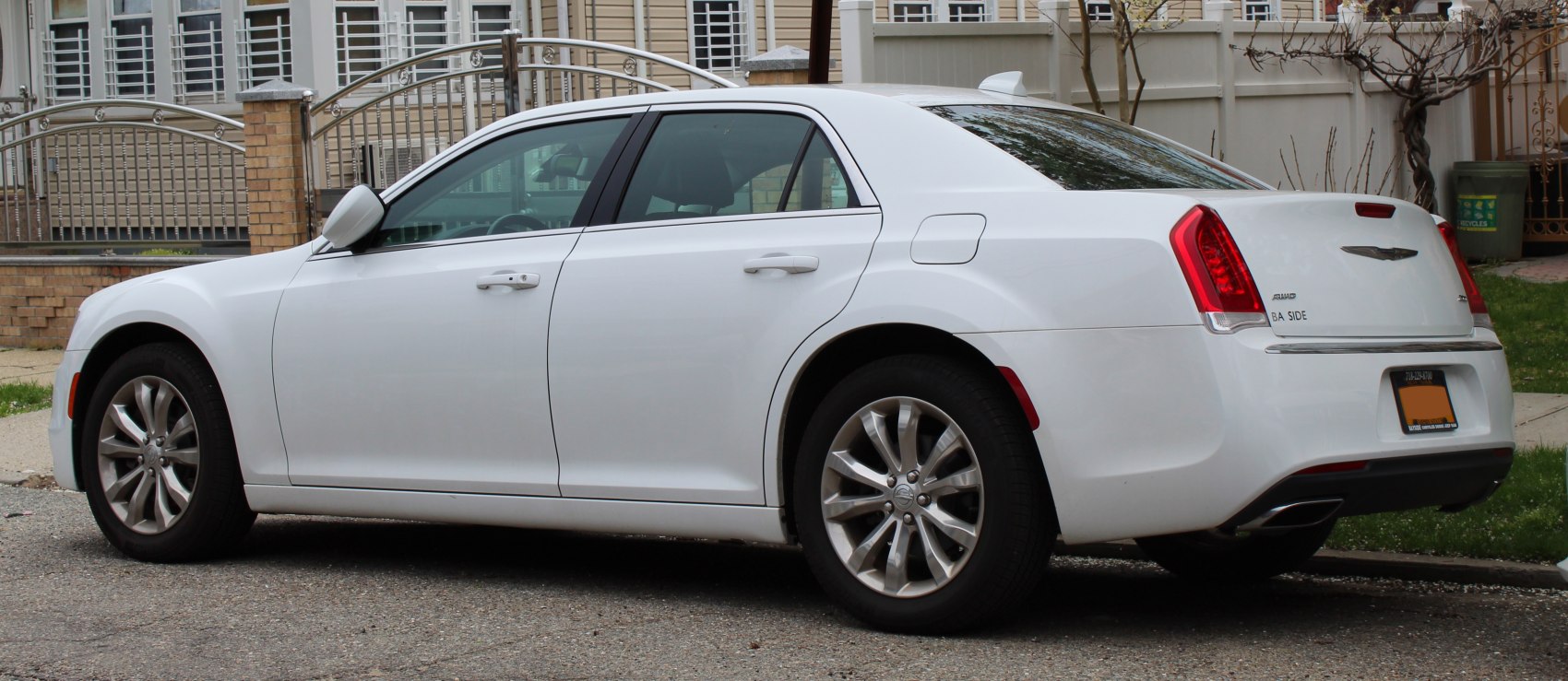 Rear side view of white sedan with alloy wheels and distinctive tail lights