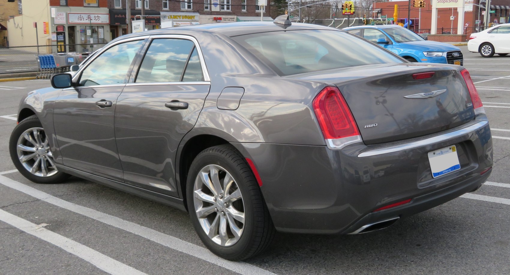 Rear and side profile of gray sedan with AWD badge and alloy wheels