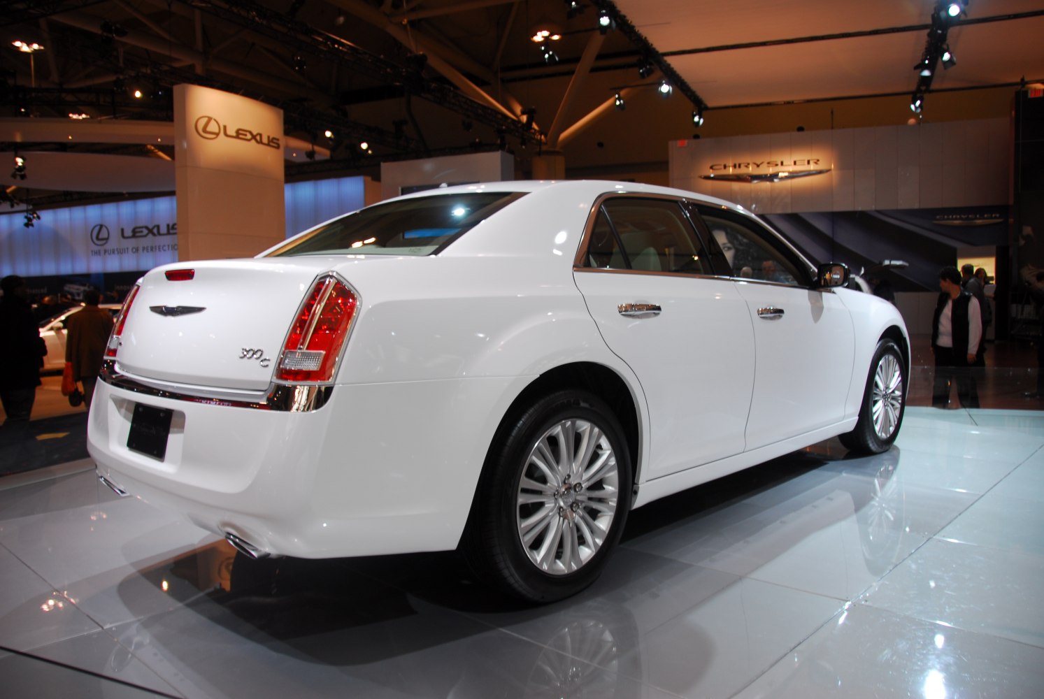 Rear side view of a white luxury sedan with chrome details and alloy wheels