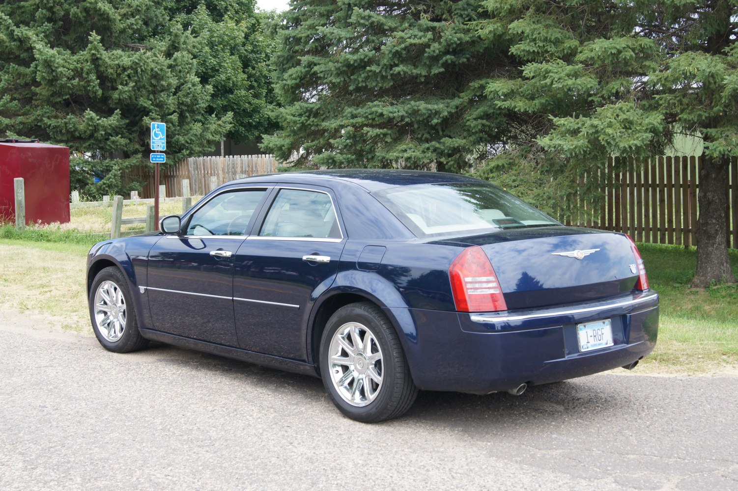 Rear side of a sedan with chrome wheels and distinct taillights