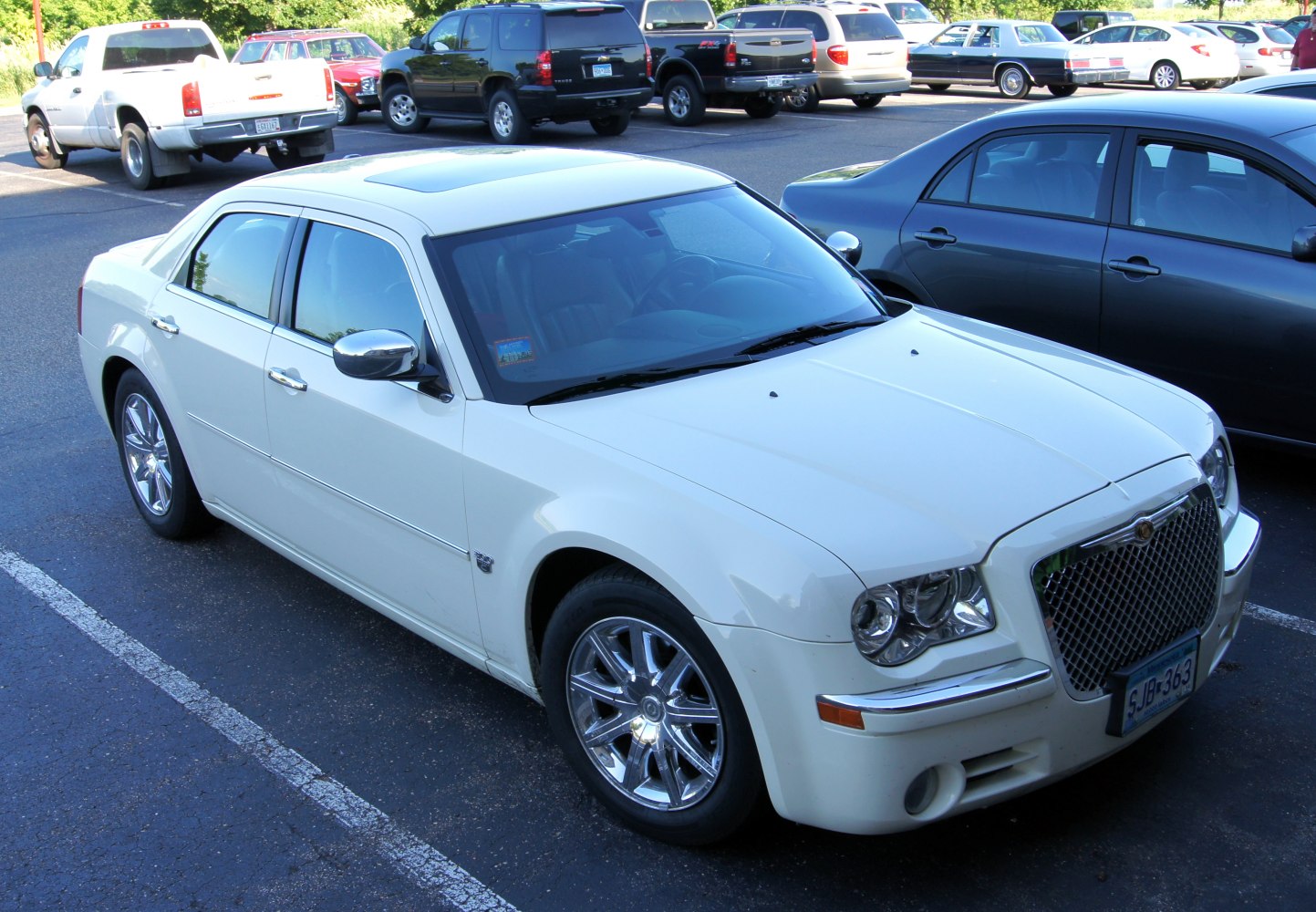 White luxury sedan with chrome grille and chrome alloy wheels.