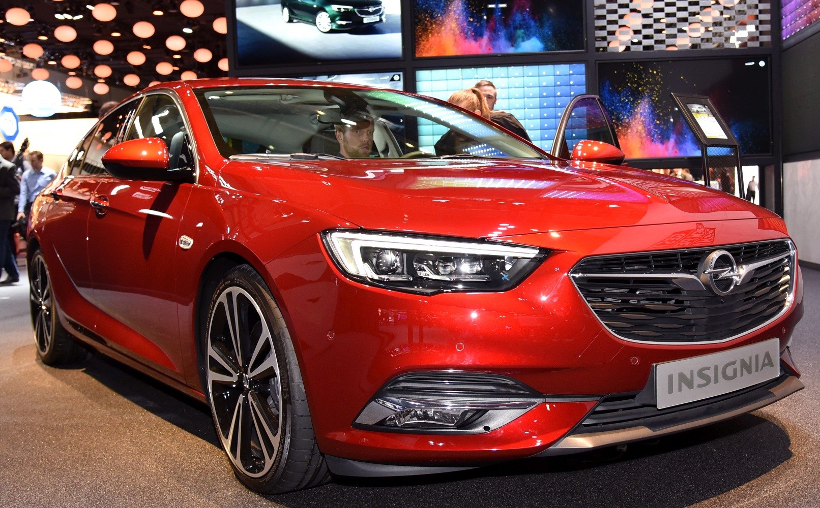 Red sedan front with grille, LED headlight, and alloy wheel