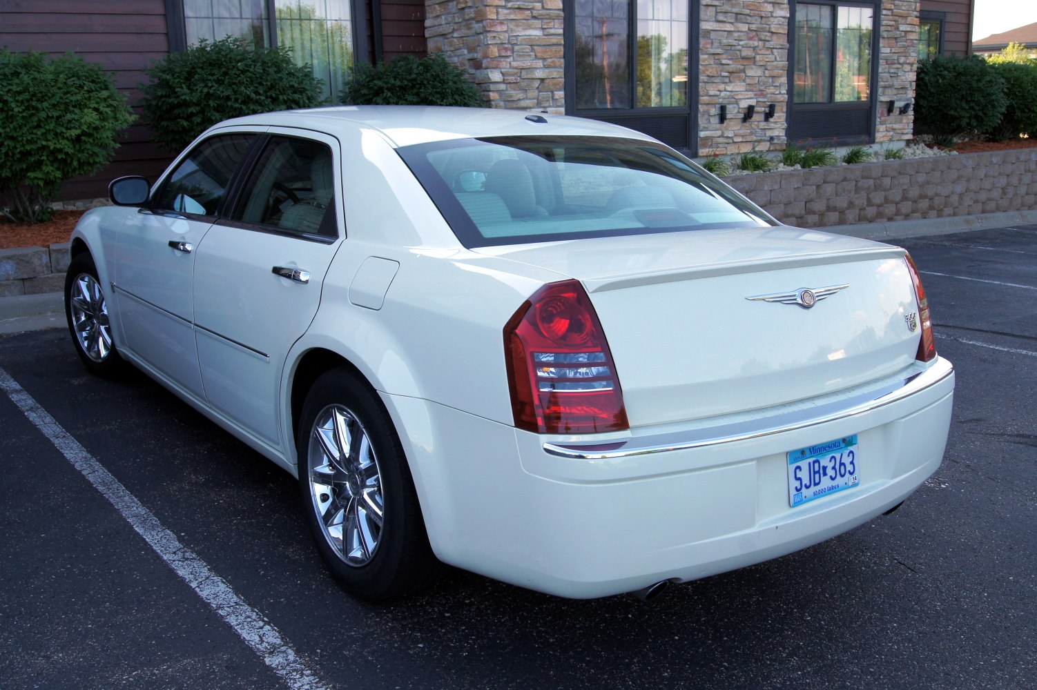 Rear side view with chrome wheels and distinctive taillights