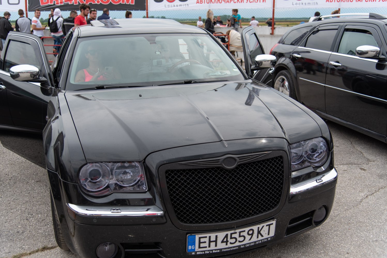 Close-up of car front grille and circular headlights with chrome trim