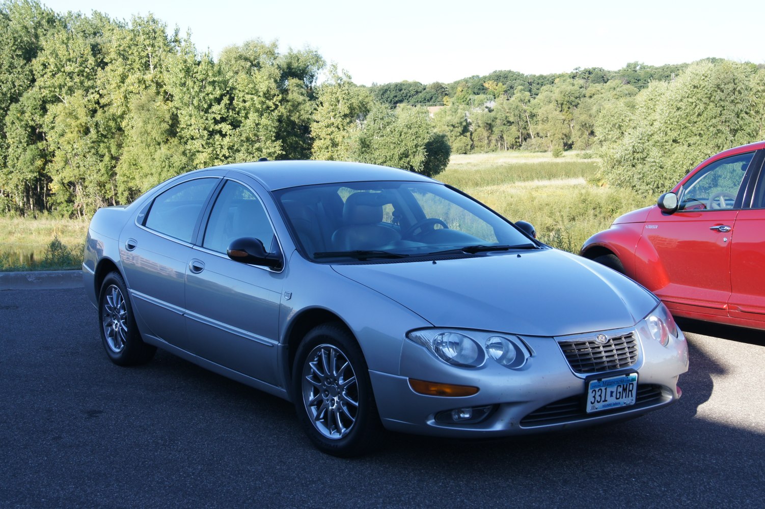Silver sedan with dual circular headlights and chrome wheels