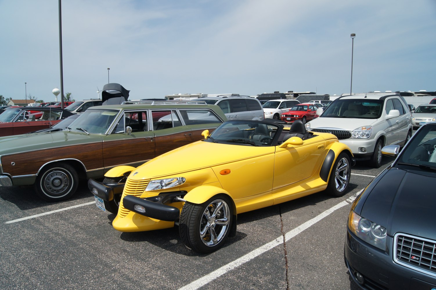 Yellow convertible roadster with chrome wheels and distinctive open fenders.