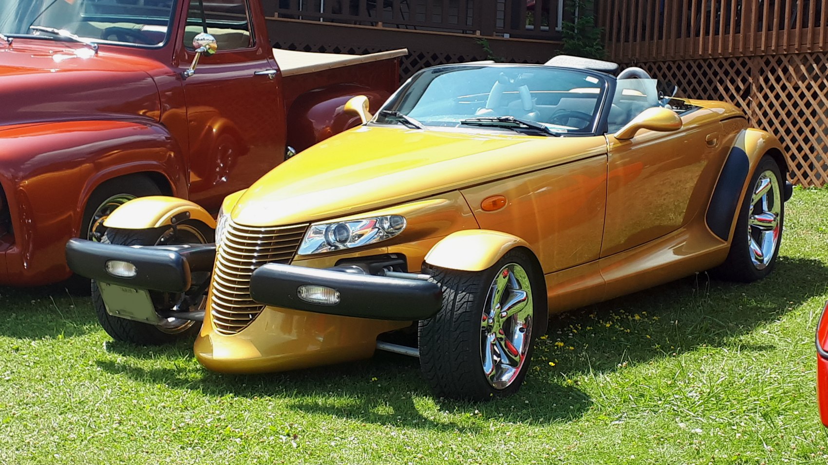 Retro-style roadster with open front wheels and chrome rims in gold.