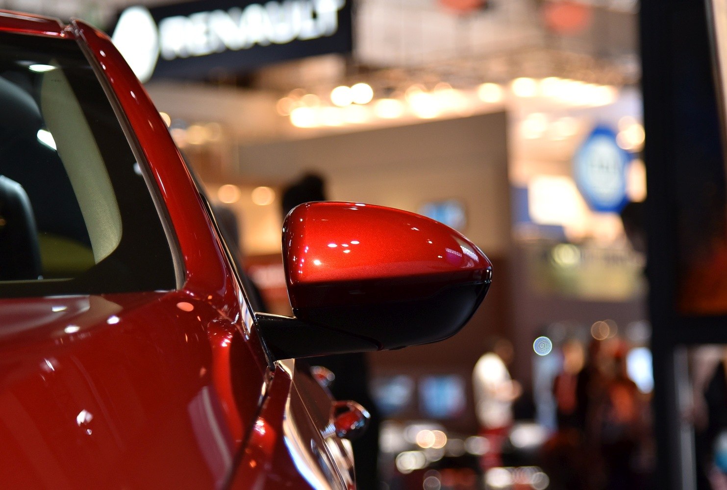 Close-up of a glossy red aerodynamic side mirror