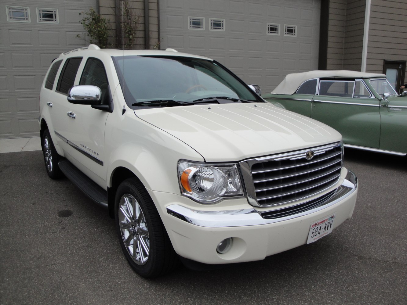 Large chrome grille and chrome side mirrors on white SUV