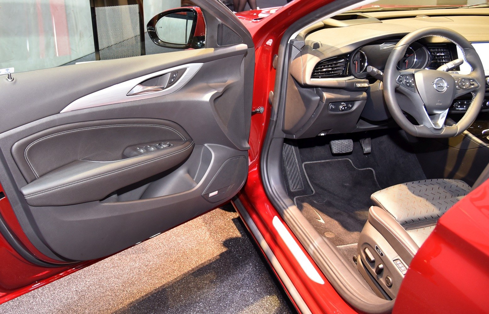 Driver door panel and front seat with steering wheel and pedals