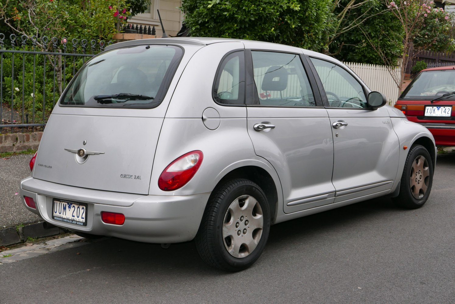 Rear side view of retro hatchback with silver paint and rounded design.