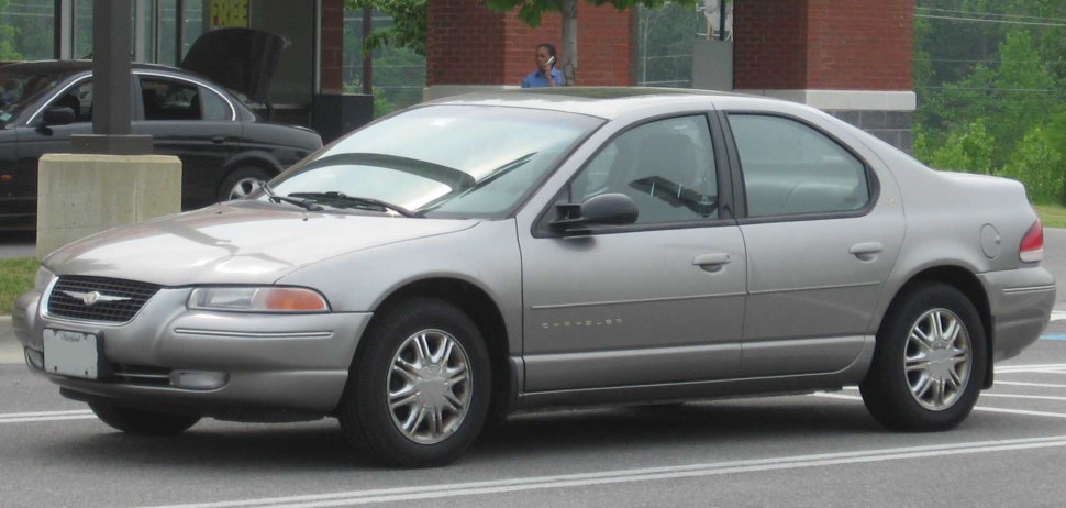 Side profile of silver four-door sedan with chrome multi-spoke wheels