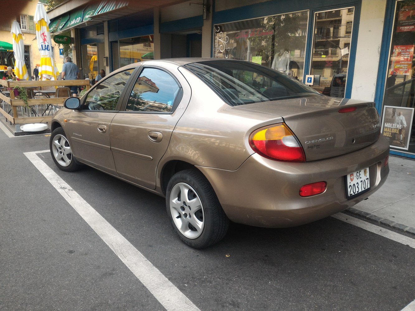 Rear side of compact sedan with alloy wheels parked on street.