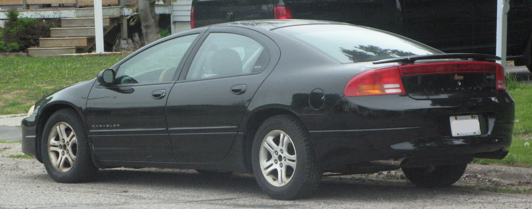 Rear and side view of black sedan with spoiler and alloy wheels