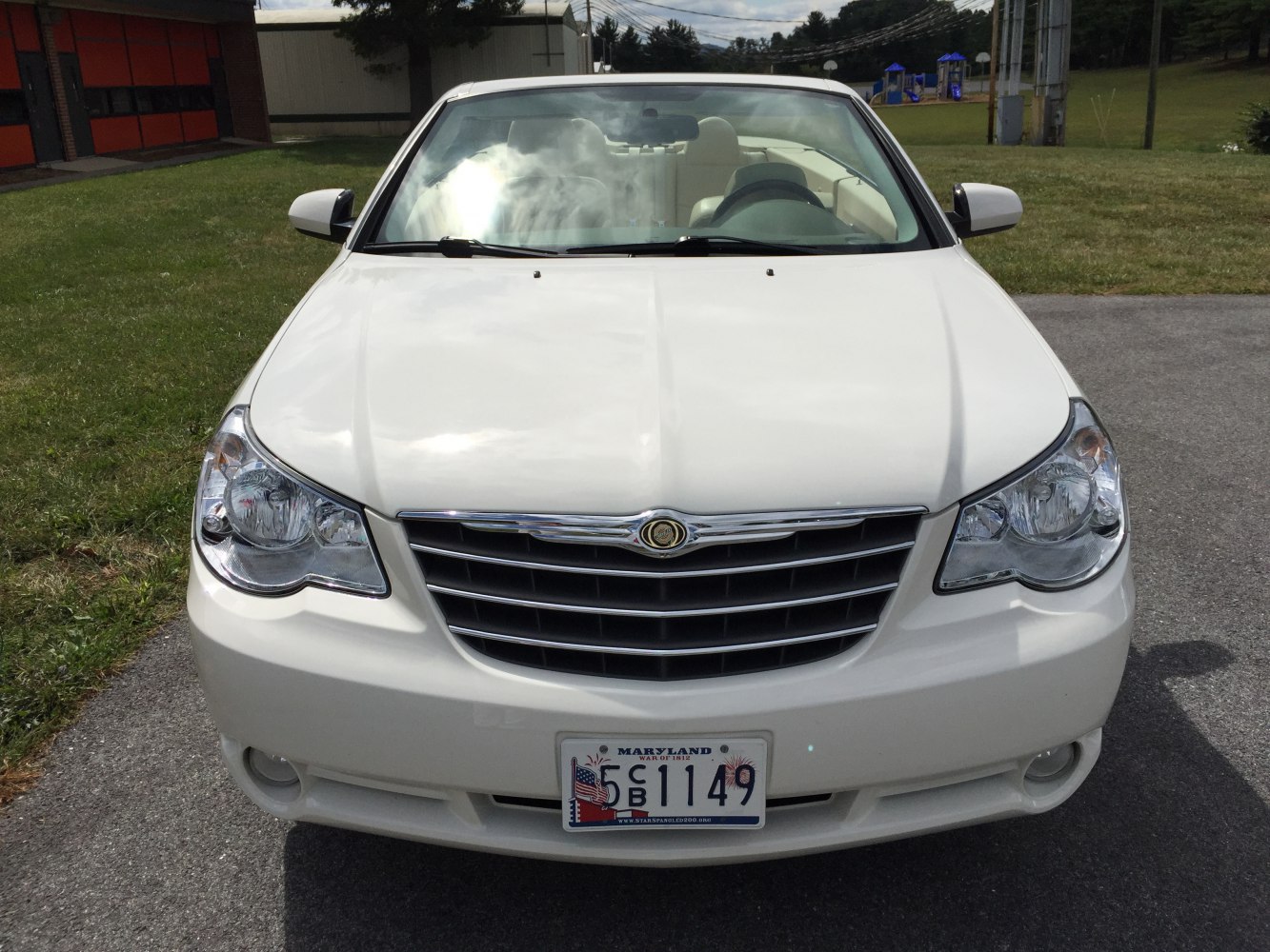Front view of white convertible with chrome grille and dual headlights