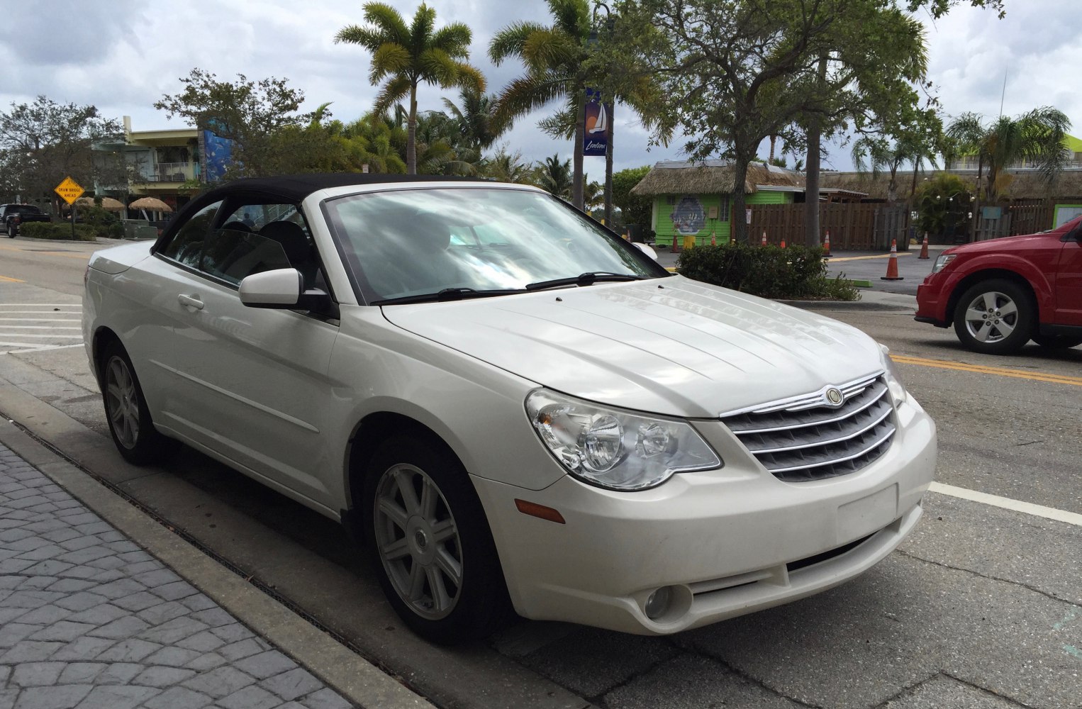 Convertible with soft black top and chrome front grille.