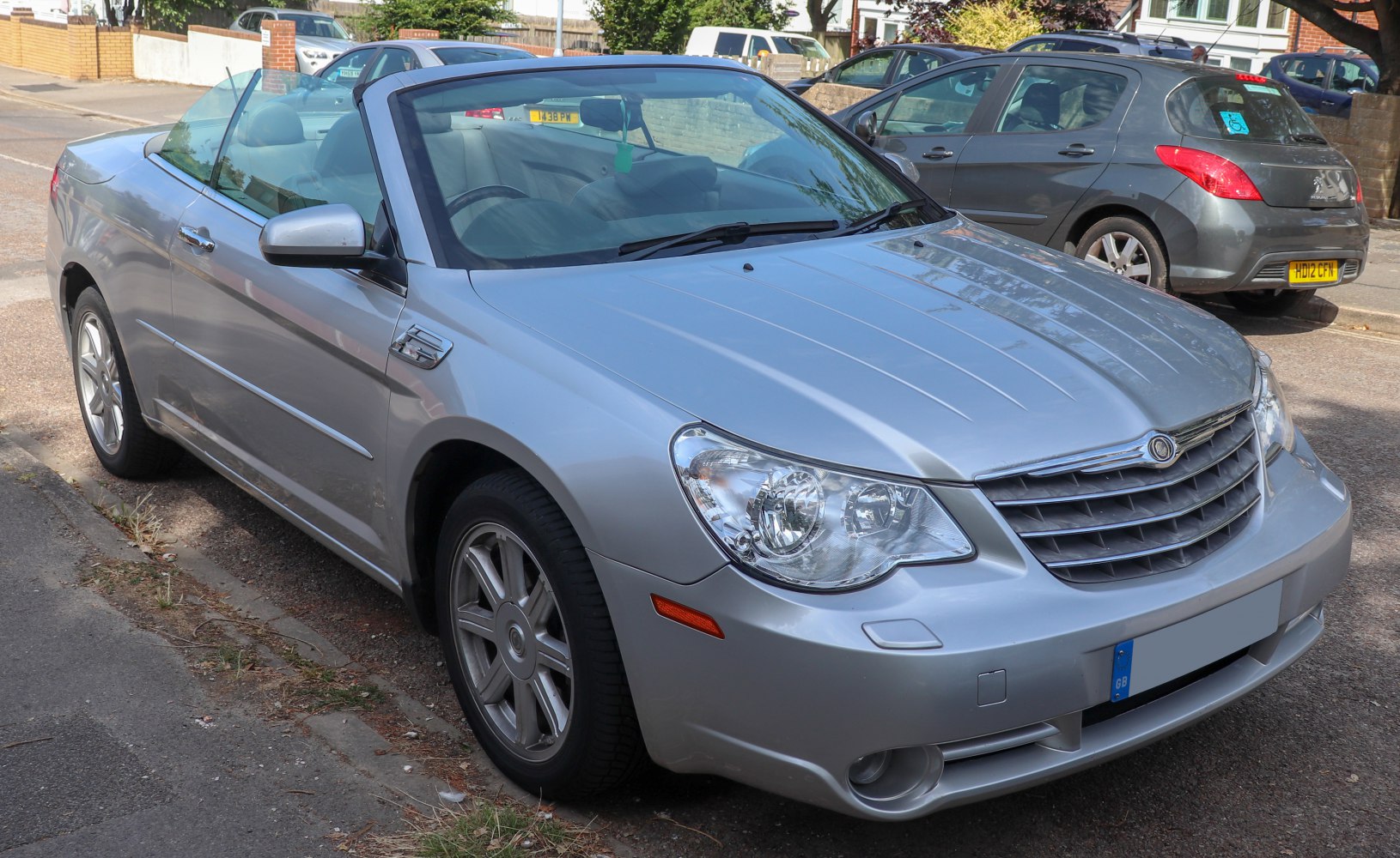 Silver convertible with prominent front grille and alloy wheels