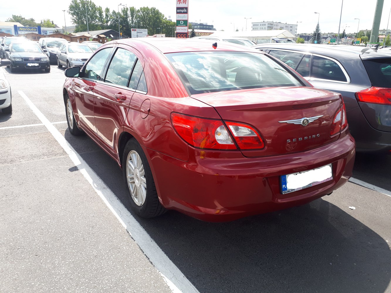 Red sedan rear view with distinct tail lights and trunk design