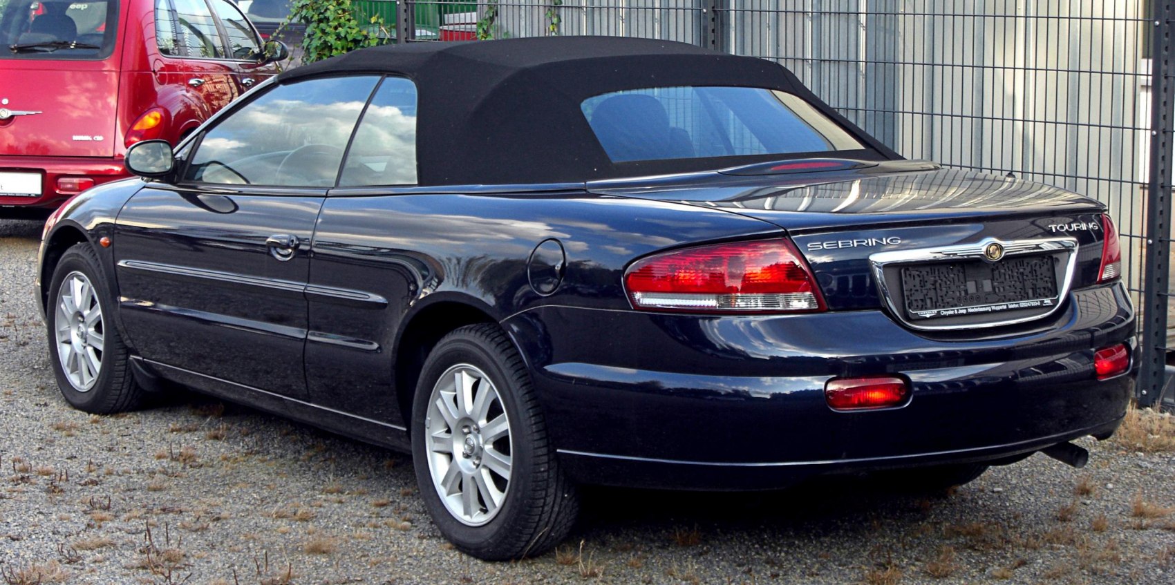 Rear side view of black convertible with soft top and alloy wheels