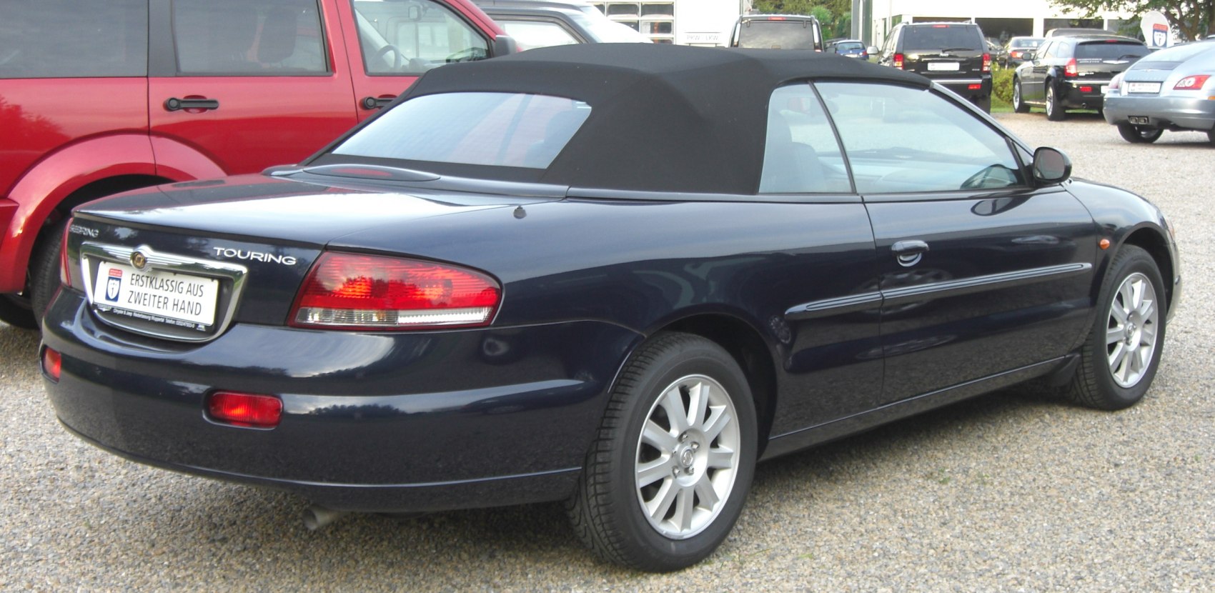 Rear side view of a convertible with soft top and Touring trim