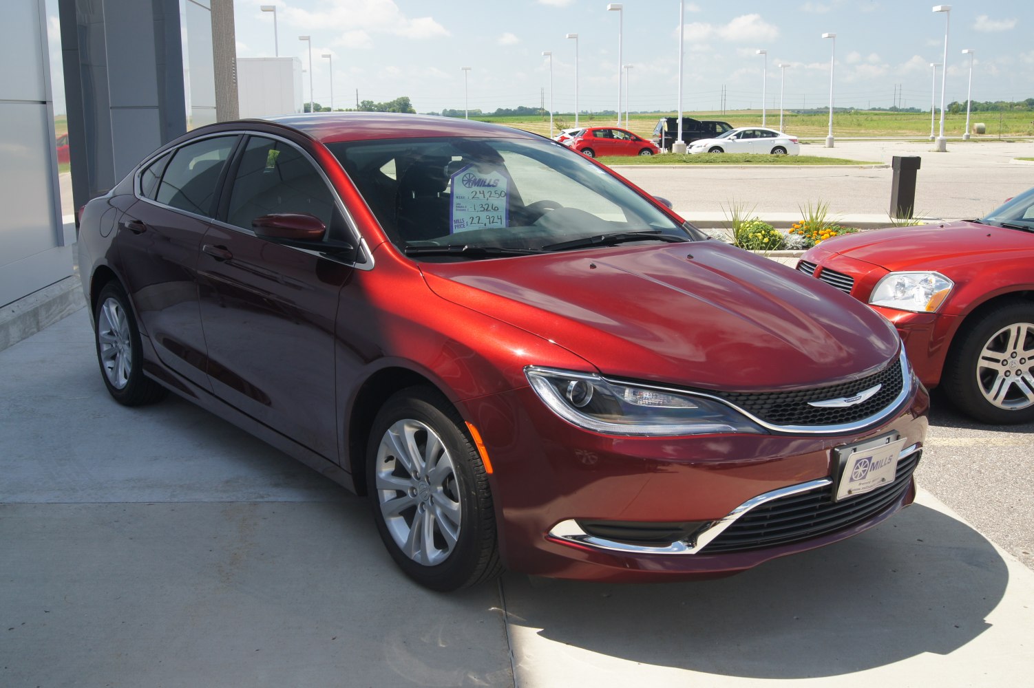 Front angled view of red sedan with sleek headlights and modern grille.