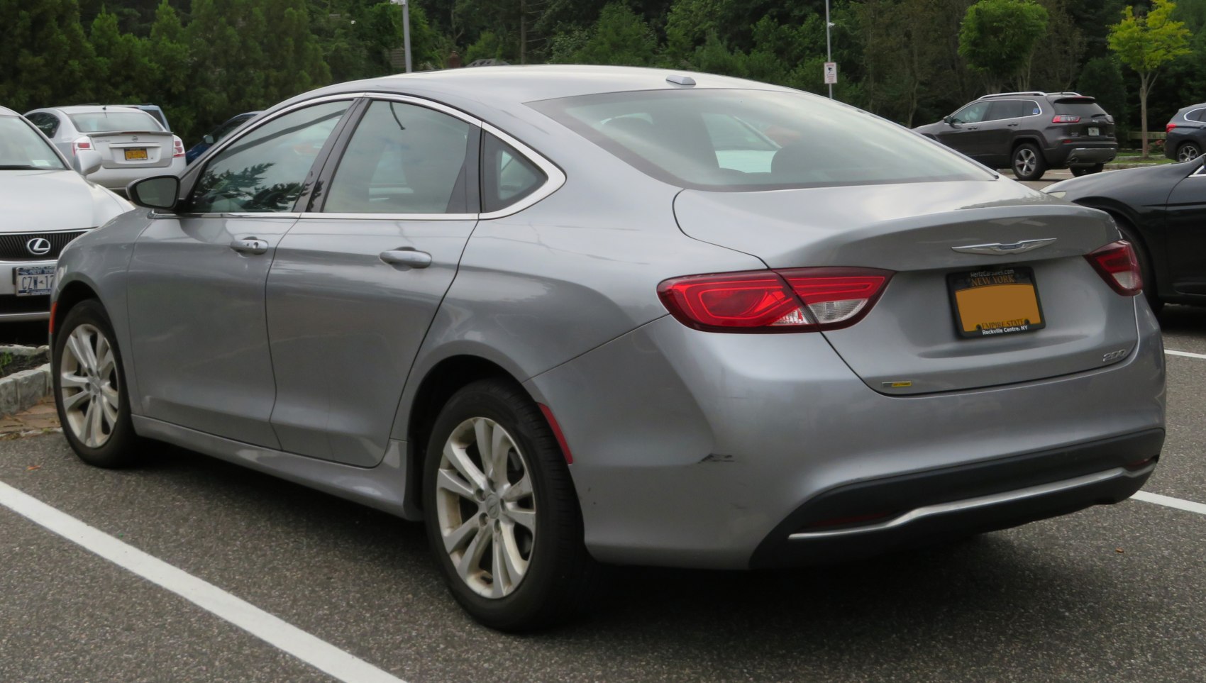 Rear side view of silver sedan with sculpted tail lights and alloy wheels