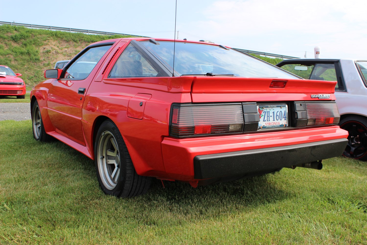 Rear view of red coupe with distinct tail lights and rear spoiler