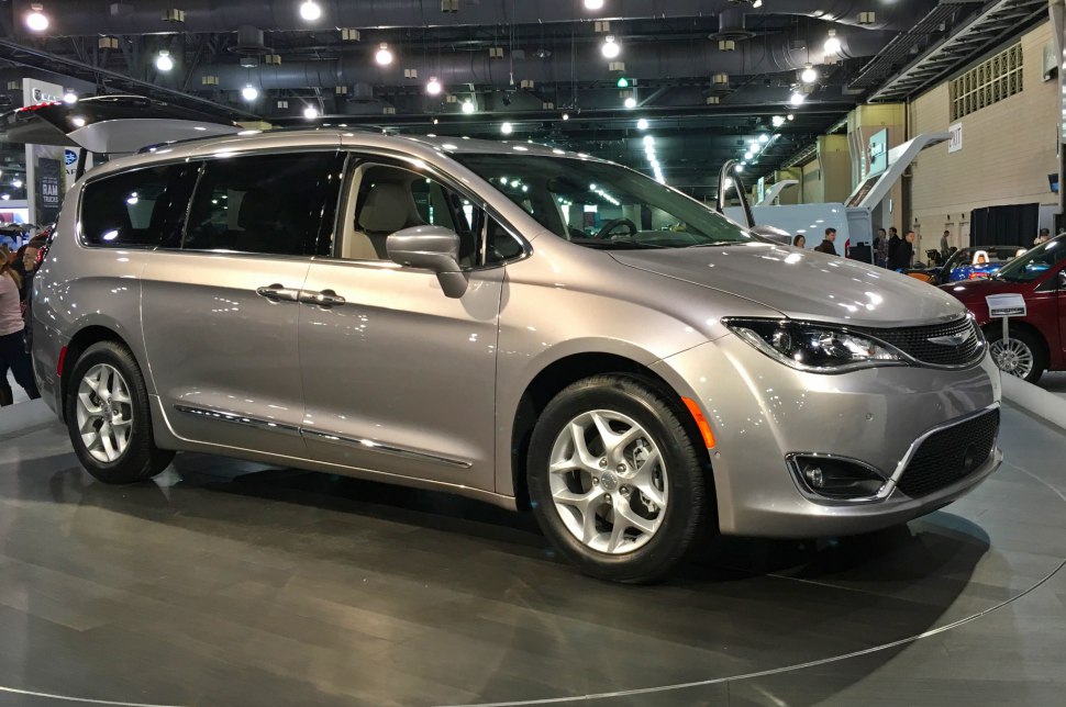Silver minivan side view with alloy wheels at auto show