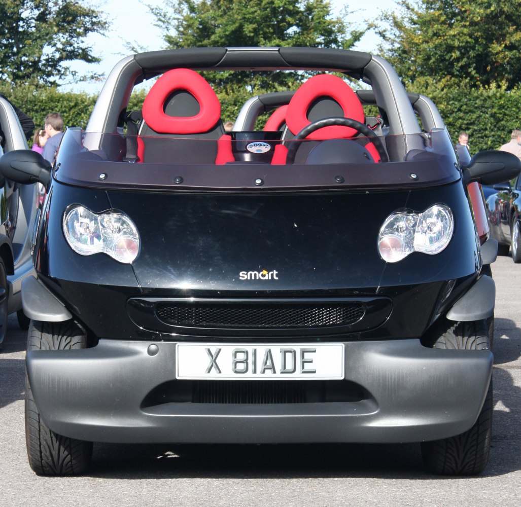 Front view of compact open-air car with red headrests