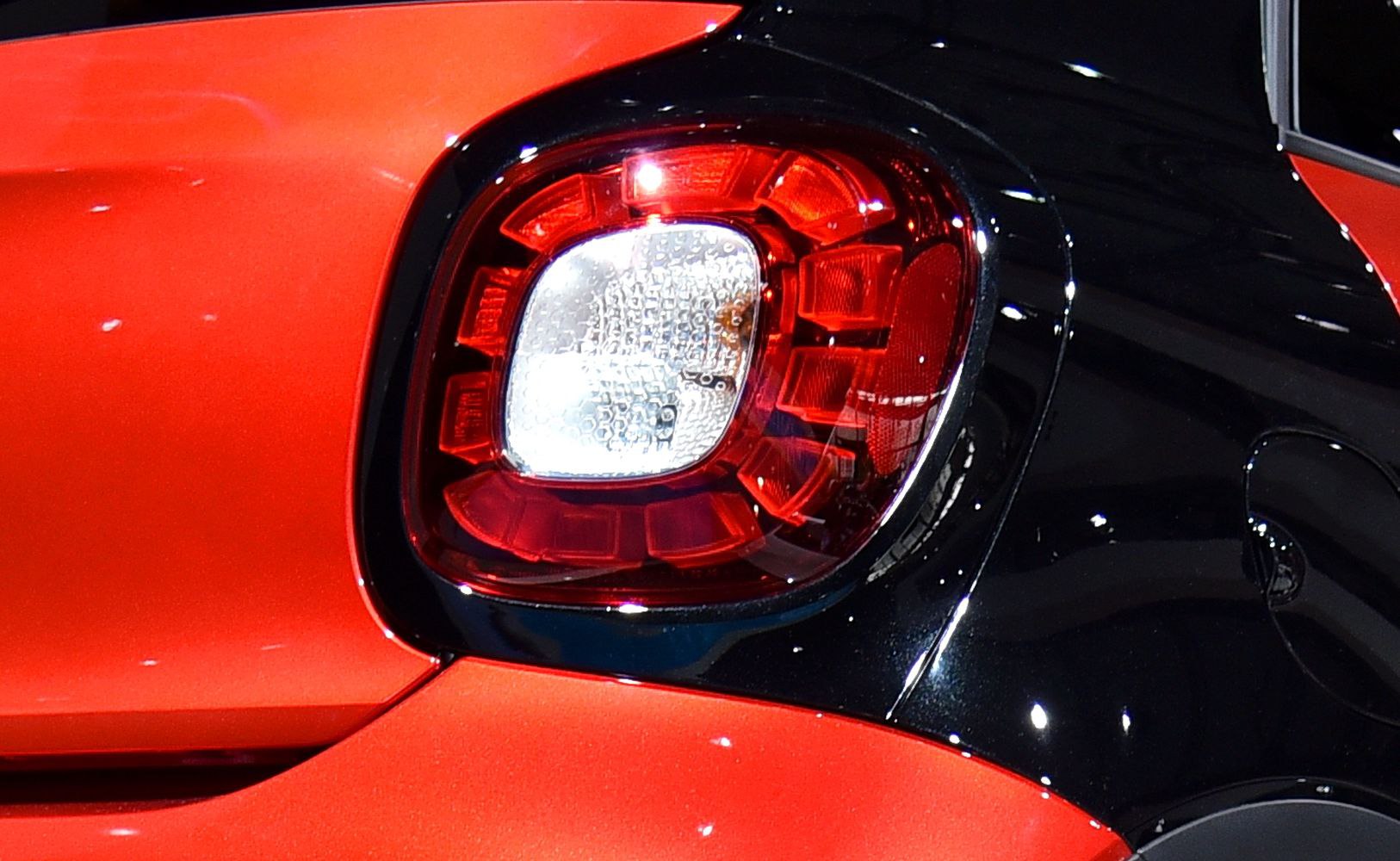 Close-up of red and white rear light with glossy black surrounding